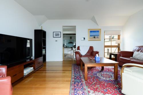 a living room with a couch and a coffee table at Cameron Mews: In The Heart Of The City in Launceston