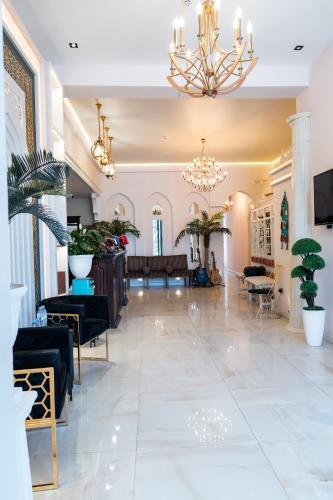 a lobby with a chandelier and potted plants at Meros Boutique Hotel in Samarkand