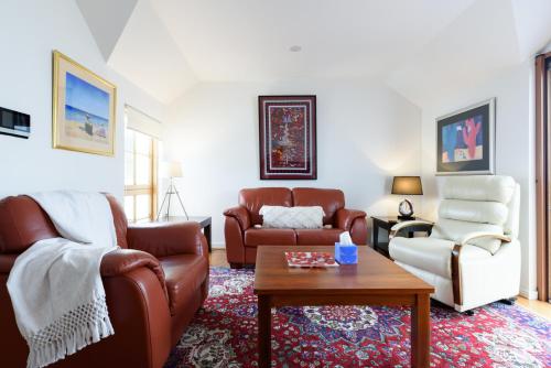 a living room with a couch and a table at Cameron Mews: In The Heart Of The City in Launceston