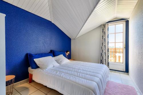 une chambre bleue avec un lit et une fenêtre dans l'établissement Résidence Port Bourgenay - maeva Home - Appartement 4 pièces 8 personnes - Sélection MAE-4721, à Talmont-Saint-Hilaire