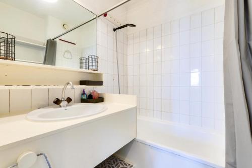 La salle de bains blanche est pourvue d'un lavabo et d'une baignoire. dans l'établissement Résidence Port Bourgenay - maeva Home - Appartement 4 pièces 8 personnes - Sélection MAE-4721, à Talmont-Saint-Hilaire