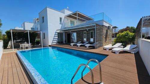 a house with a swimming pool in front of a house at Kyma 3 Bed Villa + Pool in Paphos