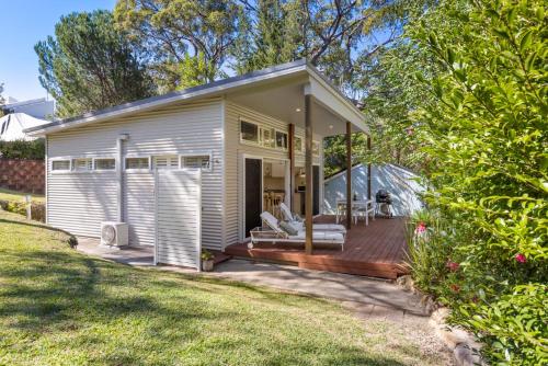 a small house with a large deck and a porch at Studio By The Bay in Vincentia