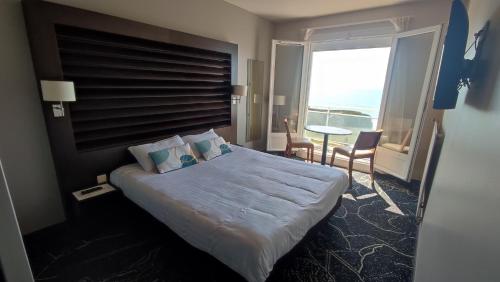 une chambre d'hôtel avec un lit et une grande fenêtre dans l'établissement Hotel La Corniche, à Saint-Hilaire-de-Riez