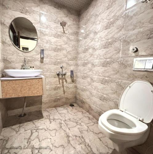 a bathroom with a toilet and a sink and a mirror at Lords Grey near Mall Road in Shimla