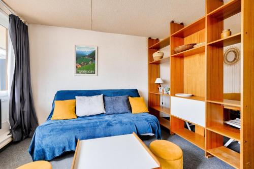 - une chambre avec un lit bleu et des étagères en bois dans l'établissement Résidence Le Tourmalet - maeva Home - Studio 4 personnes - Sélection MAE-0631, à La Mongie