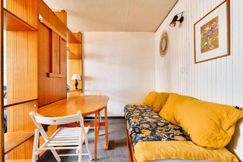 Cette chambre comprend un bureau, une table et un canapé. dans l'établissement Résidence Le Tourmalet - maeva Home - Studio 4 personnes - Sélection MAE-0631, à La Mongie