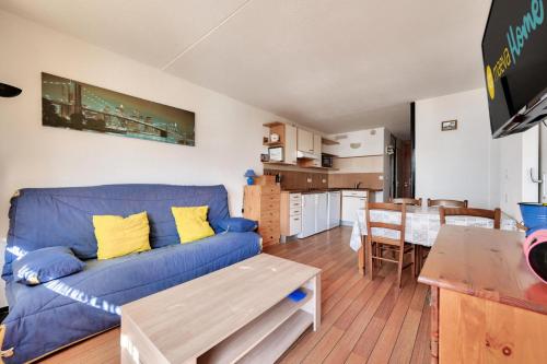 un salon avec un canapé bleu et une table dans l'établissement Résidence Le Tourmalet - maeva Home - Appartement 3 pièces 6 personnes - Confort MAE-9821, à La Mongie