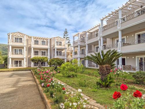 a large white building with flowers in front of it at Thinalos Hotel in Saoúli