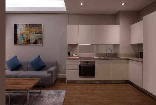 a kitchen and living room with a couch and a table at Movenpick Living Istanbul West in Istanbul