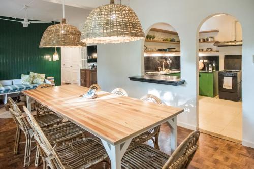 a kitchen and dining room with a wooden table and chairs at Rainforest Nest - CAHAYA, PITI, VIRYA Nest with Self-Service Breakfast, Balcony, Monkeys, Bats! in Subic Bay Intl