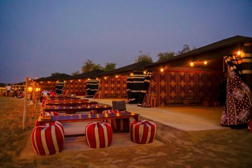 a group of tables in front of a building with lights at Al Marmoom Oasis Luxury Tents and Bedouin Experience in Dubai