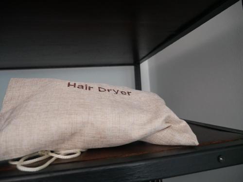a pillow with the words hair dryer sitting on a shelf at P168 Hostel Samui in Chaweng