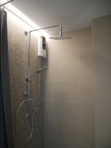 a shower with a shower head in a bathroom at P168 Hostel Samui in Chaweng