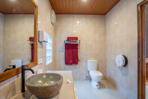 a bathroom with a sink and a toilet at Rumah Gajah by Kubukubali in Pemuteran