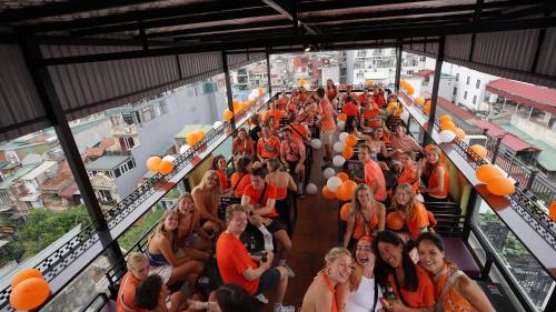 a group of people in orange shirts on a building at Lakeview Backpackers Hostel & Rooftop Bar in Hanoi