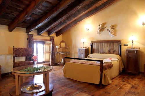 une chambre avec un lit et une table dans une pièce dans l'établissement Casa Rural Botica Gomelia II, à Gumiel de Hizán
