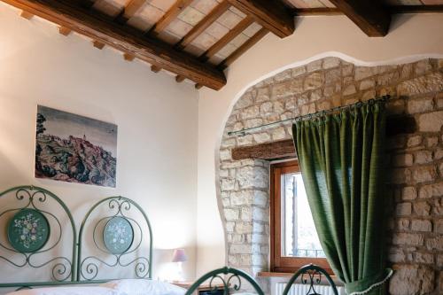 a bedroom with a bed and a window at Le Fontanelle Country House in SantʼIppolito