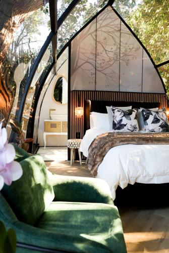 a bedroom with a large bed with a large window at De Nest - Clear Glass Tree Cabin in Montagu