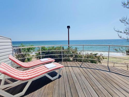 a pair of chairs sitting on a deck overlooking the beach at Котеджі на приватному пляжу - Совіньйон 2025 in Odesa