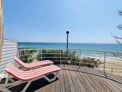 two chairs sitting on a deck looking at the ocean at Котеджі на приватному пляжу - Совіньйон 2025 in Odesa