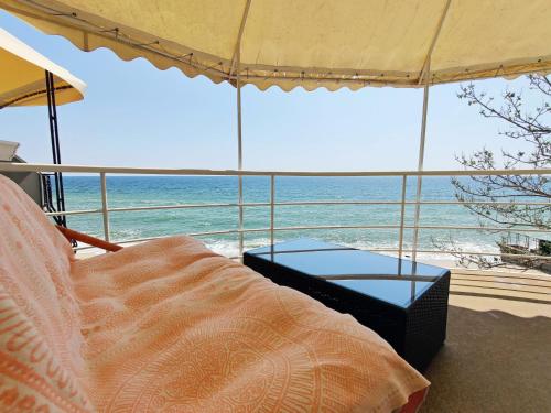 a bed and an umbrella on the beach at Котеджі на приватному пляжу - Совіньйон 2025 in Odesa