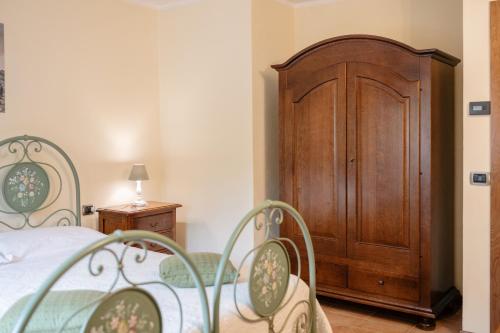 a bedroom with a bed and a wooden cabinet at Le Fontanelle Country House in SantʼIppolito