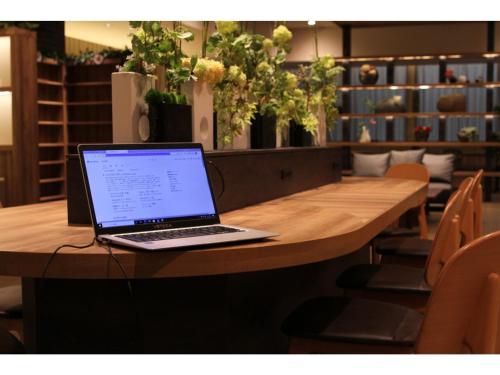 a laptop computer sitting on top of a wooden table at KAJIMACHI NO YU SPA SOLANI - Vacation STAY 26781v in Hamamatsu