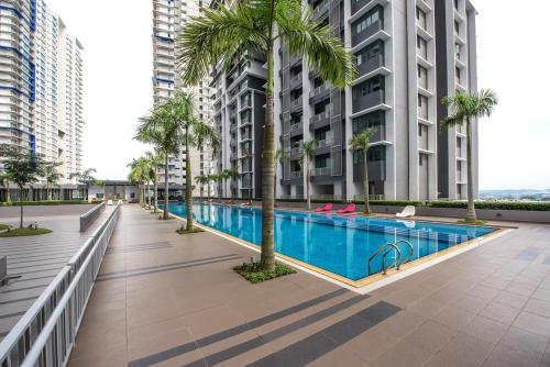 a swimming pool with palm trees and buildings at The Makcik's Homestay at Almyra Residence in Kajang