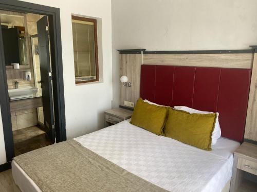 a bedroom with a large bed with a red headboard at Akkan Beach Hotel in Bodrum City