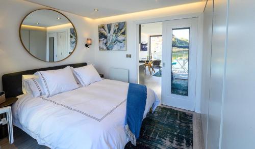 a bedroom with a large white bed and a mirror at Houseboat in Kinsale in Kinsale