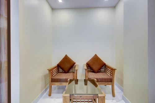 two chairs and a coffee table in a room at Hotel Urban Lion - IGI Airport Delhi in New Delhi