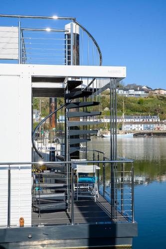 a dock with a staircase on a boat in the water at Houseboat in Kinsale in Kinsale