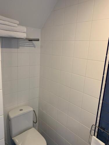 a white bathroom with a toilet and towels at Nordes in Ragaciems