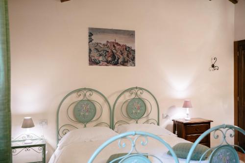 a bedroom with a bed and a painting on the wall at Le Fontanelle Country House in SantʼIppolito