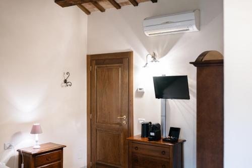 a room with a door and a bed and a television at Le Fontanelle Country House in SantʼIppolito