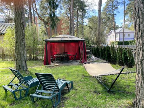 a group of chairs and a hammock in a yard at Dacha Apart Hotel in Jūrmala