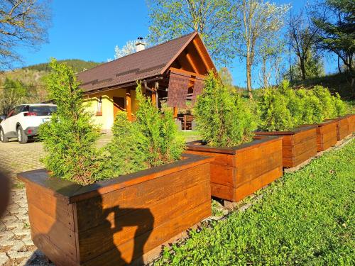 a row of wooden planters filled with potted plants at Vila Pohoda Javorníky s rozľahlým pozemkom in Makov