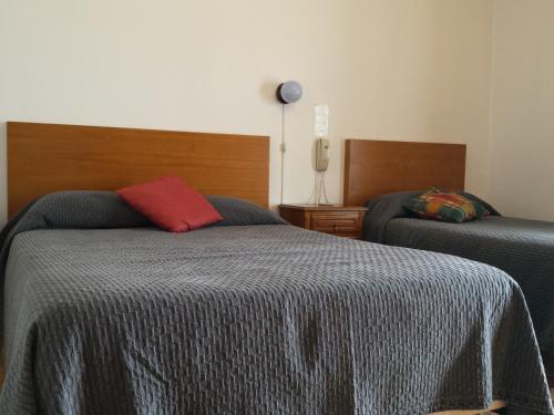 a bedroom with two beds and a lamp at Pensao Vista Bela in Miranda do Douro