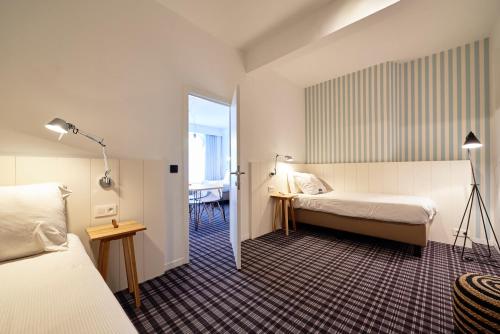 a hotel room with two beds and a window at Leopold Hotel Ostend in Ostend