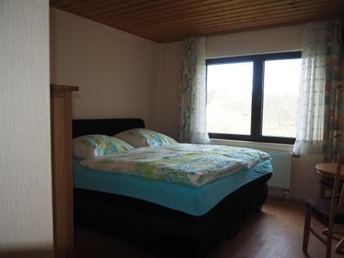 a bedroom with a bed with a window at Zur Kringelwies in Masburg