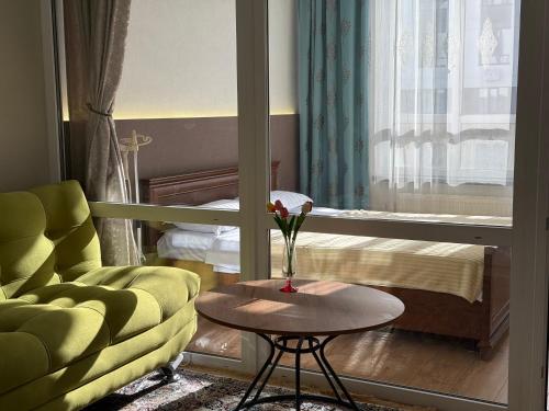 Una sala de estar con un sofá, una mesa y una cama. en Modern apartment in the city center with 3 rooms studio, en Almaty