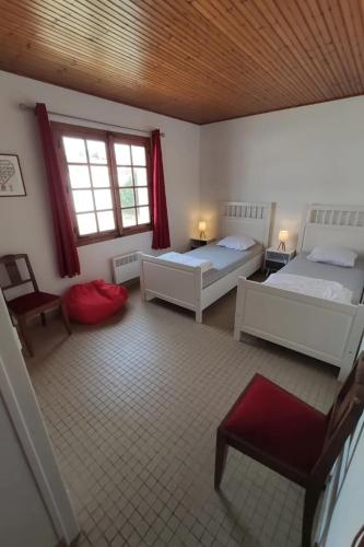 Cette grande chambre comprend deux lits et une fenêtre. dans l'établissement NO B'Elvi - Maison située à Épine - Plage à 800 M, à LʼÉpine