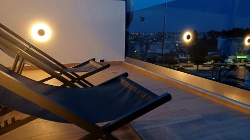 a chair on a balcony with a view of a city at attico di lusso in Komotini