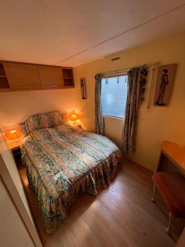 une petite chambre avec un lit et une fenêtre dans l'établissement Mobilhome de Gigi, au Grau-dʼAgde