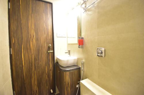 a bathroom with a sink and a mirror at Urban Nest in Mumbai