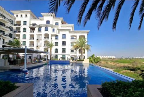 a hotel with a swimming pool in front of a building at The Green Keepers Look-out in Abu Dhabi