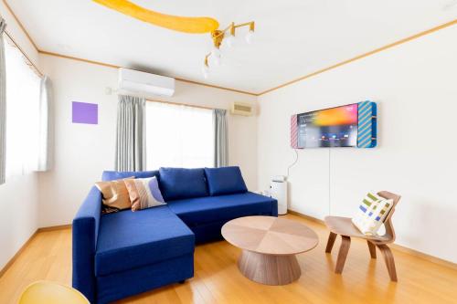 a living room with a blue couch and a table at Universal Koryuun in Osaka