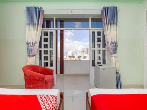 a living room with a red chair and a window at OYO 898 Phuong Thao Hotel in Nha Trang