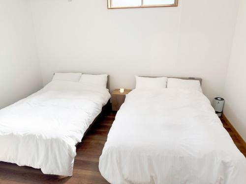 two beds sitting next to each other in a room at マーケットステイ串本 MarketStay Kusimoto in Kushimoto